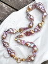 Necklace with pink and gold baroque freshwater pearls on a white dish