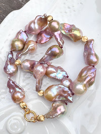Baroque pearl necklace with gold accents on a decorative plate
